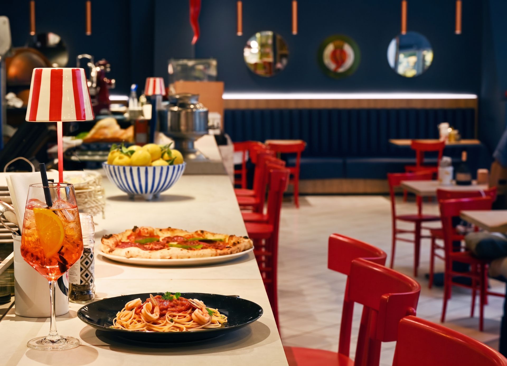 Ovest Bar im KaDeWe Berlin am Abend – Aperol Spritz, neapolitanische Pizza und Spaghetti mit Meeresfrüchten auf dem Tresen des italienischen Restaurants